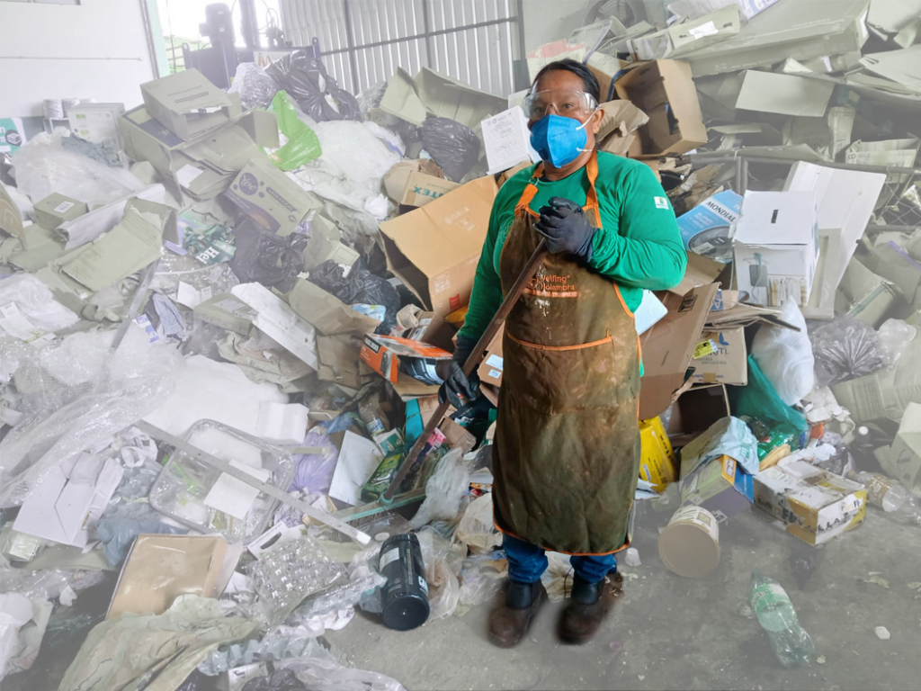 Catadora trabalha em uma pilha de lixo reciclável