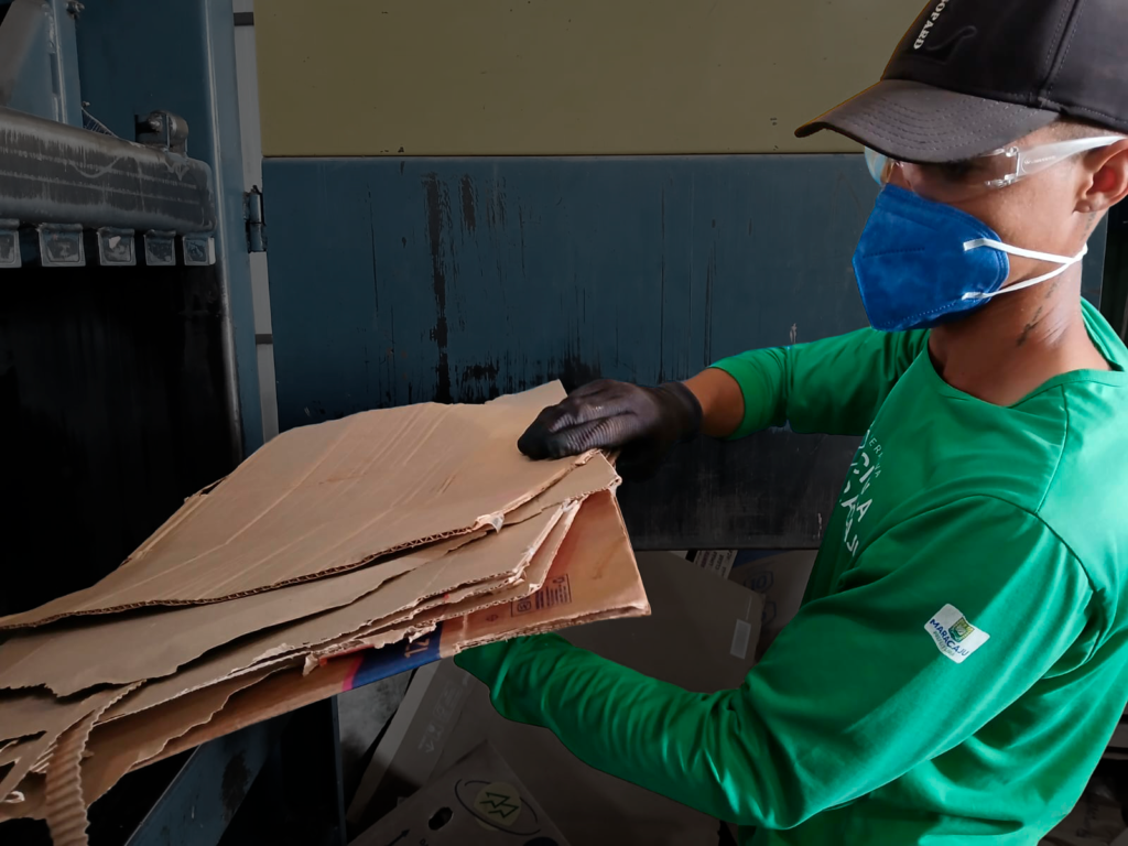 Catador separa papelão para ser tratado.